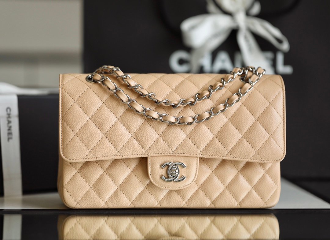 Apricot beige Chanel Medium Classic Double Flap Bag in caviar leather with silver-tone CC hardware and chain strap.